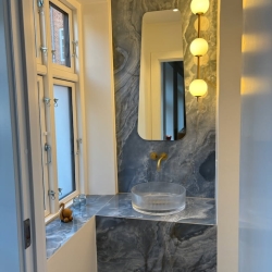 Unik håndvaskeløsning med specialtilpassede overflader lavet af murer ved renovering af badeværelse i Farsø og omegn.